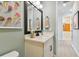 Bright bathroom with white vanity, black accents, and colorful artwork at 11313 Hardwood Hammock Ln, Riverview, FL 33569