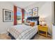 Bedroom featuring a plaid bedspread, framed artwork, and yellow nightstands at 11313 Hardwood Hammock Ln, Riverview, FL 33569