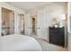 Neutral bedroom with a mirror, black dresser, and white doors at 11313 Hardwood Hammock Ln, Riverview, FL 33569