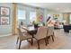 Cozy dining area with a wooden table, four chairs, and ample natural light from nearby windows, adjacent to the living room at 11313 Hardwood Hammock Ln, Riverview, FL 33569