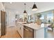 Open kitchen showcases a large center island with a sink, pendant lights, stainless steel appliances, and a view into the living space at 11313 Hardwood Hammock Ln, Riverview, FL 33569