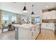 Well-lit kitchen with an island, white cabinets, stainless steel appliances, and a seamless view into the dining area at 11313 Hardwood Hammock Ln, Riverview, FL 33569