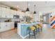 Bright kitchen with a large island, white cabinets, stainless steel appliances, and modern pendant lighting at 11313 Hardwood Hammock Ln, Riverview, FL 33569