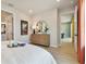 Bright main bedroom featuring a dresser, a framed picture, a bed, and an en-suite bathroom at 11313 Hardwood Hammock Ln, Riverview, FL 33569