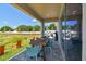 Covered patio features a wood dining table, blue chairs, and access to the backyard at 11313 Hardwood Hammock Ln, Riverview, FL 33569