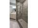 Modern bathroom features a glass enclosed shower with gray tiling, grab bars, and a single sink vanity with tile flooring at 11510 Shipwatch Dr # 1372, Largo, FL 33774