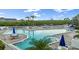 Relaxing community pool and lounge area with inviting blue umbrellas and plenty of space to enjoy the outdoors at 11510 Shipwatch Dr # 1372, Largo, FL 33774