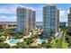 Stunning aerial view of luxury high-rise condos with pools, tropical landscaping, and bay views at 1170 Gulf Blvd # 1006, Clearwater Beach, FL 33767