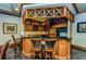 Cozy bar area with dark marble countertops, wooden cabinets, and seating for guests at 1170 Gulf Blvd # 1006, Clearwater Beach, FL 33767