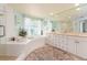 Bright bathroom featuring a tub, shower, vanity and round rug at 1170 Gulf Blvd # 1006, Clearwater Beach, FL 33767