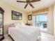Bright bedroom featuring a ceiling fan, tile flooring, and balcony access at 1170 Gulf Blvd # 1006, Clearwater Beach, FL 33767