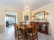Elegant dining room featuring a wooden table, decorative mirror, and chandelier lighting at 1170 Gulf Blvd # 1006, Clearwater Beach, FL 33767