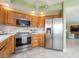 Modern kitchen featuring stainless steel appliances, tile flooring, and wood cabinetry at 1170 Gulf Blvd # 1006, Clearwater Beach, FL 33767
