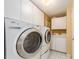 Functional laundry room with a sink, storage cabinets, and white appliances at 1170 Gulf Blvd # 1006, Clearwater Beach, FL 33767