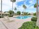 Outdoor pool with lounge chairs, umbrellas, palm trees, and lush green landscaping at 1170 Gulf Blvd # 1006, Clearwater Beach, FL 33767