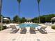 Relaxing pool area surrounded by lounge chairs and lush landscaping in a tropical setting at 1170 Gulf Blvd # 1006, Clearwater Beach, FL 33767