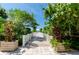 Picturesque wooden walkway leading to a beachside gazebo, surrounded by tropical foliage and plants at 1170 Gulf Blvd # 1006, Clearwater Beach, FL 33767