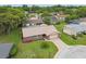 Aerial view of a single-Gathering home, showcasing the landscaping and driveway in a residential neighborhood at 12101 Meadowbrook Ln, Hudson, FL 34667