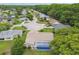 An aerial view of a neighborhood featuring a single-Gathering home with a screened pool and lush trees at 12101 Meadowbrook Ln, Hudson, FL 34667