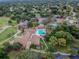 Aerial view showcasing community pool, clubhouse, and tennis courts surrounded by green landscape at 12101 Meadowbrook Ln, Hudson, FL 34667