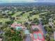 Aerial view showing the community golf course, clubhouse, tennis and basketball courts and pool at 12101 Meadowbrook Ln, Hudson, FL 34667