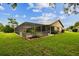 Spacious backyard featuring a screened-in lanai and lush green lawn, perfect for outdoor living at 12101 Meadowbrook Ln, Hudson, FL 34667