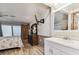 Bright view of the bedroom and attached bathroom with white vanity and decorative mirror at 12101 Meadowbrook Ln, Hudson, FL 34667