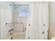 Bright bathroom featuring a tiled shower with safety bars and a window at 12101 Meadowbrook Ln, Hudson, FL 34667
