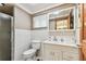 Well-lit bathroom with a white vanity, a large mirror, and a clean white toilet at 12101 Meadowbrook Ln, Hudson, FL 34667
