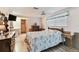 Well-lit bedroom with ceiling fan, closet, and a large window with blinds for ample natural light at 12101 Meadowbrook Ln, Hudson, FL 34667