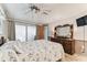 Spacious bedroom features a ceiling fan, sliding glass doors, and wooden dresser for ample storage at 12101 Meadowbrook Ln, Hudson, FL 34667