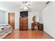 Bright bedroom with ceiling fan, wood floors, TV, and vanity/mirror at 12101 Meadowbrook Ln, Hudson, FL 34667