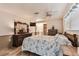 Spacious bedroom featuring a ceiling fan, a full size bed, and wooden furniture pieces at 12101 Meadowbrook Ln, Hudson, FL 34667