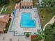 Aerial view of community pool with lounge chairs and surrounding landscape at 12101 Meadowbrook Ln, Hudson, FL 34667