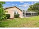 Rear exterior with screened in pool and access door at 12101 Meadowbrook Ln, Hudson, FL 34667