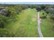Aerial view showing a golf course with a tree lined cart path at 12101 Meadowbrook Ln, Hudson, FL 34667