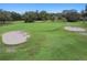 An aerial view of a picturesque golf course featuring sand traps and a green, grassy terrain at 12101 Meadowbrook Ln, Hudson, FL 34667