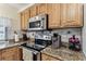 Close-up of kitchen with granite countertops and stainless steel appliances at 12101 Meadowbrook Ln, Hudson, FL 34667