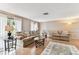 Bright living room featuring hardwood floors, neutral paint, and comfortable couches with a decorative rug at 12101 Meadowbrook Ln, Hudson, FL 34667