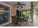Covered patio with a ceiling fan and a dining set, providing an ideal outdoor space at 12101 Meadowbrook Ln, Hudson, FL 34667