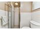Shower with glass door and tiled walls next to the toilet and window at 12101 Meadowbrook Ln, Hudson, FL 34667