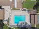 An aerial view showcases a beautiful community pool, with ample seating and a serene setting at 12101 Meadowbrook Ln, Hudson, FL 34667