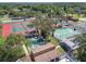 An aerial view showcases tennis courts, and shuffleboard courts with mature trees at 12101 Meadowbrook Ln, Hudson, FL 34667