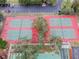 Aerial view of tennis courts and a parking lot surrounded by green landscape at 12101 Meadowbrook Ln, Hudson, FL 34667