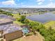 Aerial view of a home with a screened-in pool, lush landscaping, and a lake view at 12244 Fairlawn Dr, Riverview, FL 33579