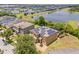 Aerial view of a suburban home featuring a solar panel roof, screened pool, and backyard overlooking a pond at 12244 Fairlawn Dr, Riverview, FL 33579