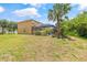 Spacious backyard featuring lush landscaping, including mature palm trees, and a screened-in pool area at 12244 Fairlawn Dr, Riverview, FL 33579