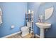 Powder room features blue walls, modern sink and fixtures, with tiled flooring at 12244 Fairlawn Dr, Riverview, FL 33579