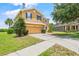 Attractive two-story home with manicured lawn, and a long driveway leading to a two-car garage at 12244 Fairlawn Dr, Riverview, FL 33579