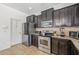Modern kitchen with stainless appliances, granite counters, dark wood cabinets, and eat-in bar at 12244 Fairlawn Dr, Riverview, FL 33579